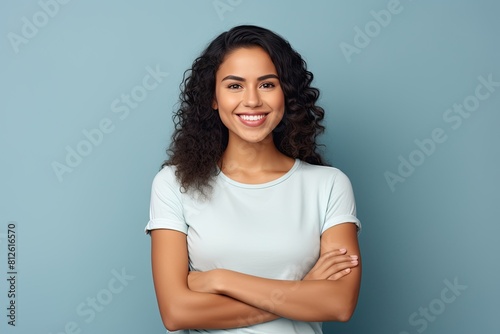 Young latin woman with pleasant smile and crossed arms.