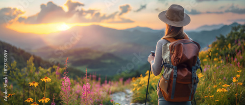 Beautiful woman wearing a hat and carrying a backpack, using a trekking pole in a mountainous landscape at sunset, ideal for themes of travel, adventure, and outdoor fitness.
