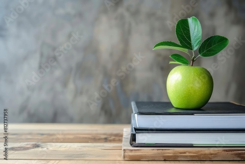A classic wooden teacher desk with an orderly pile of textbooks and a bright green apple, symbolizing education and health