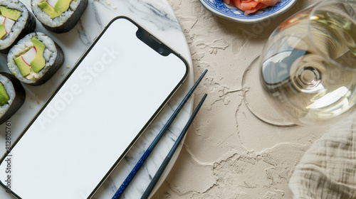 White Screen Smartphone Mockup with Sushi Dinner on Marble Table: Top View of Blank Screen Mobile Phone with Sushi Avocado, radies, Chopsticks and Glass of Wine