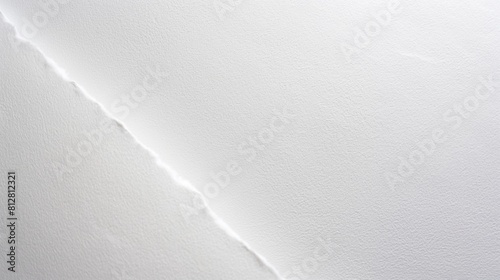 A white sheet of paper showing a comparable set of paper texture with a diagonal separating line