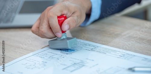 A person stamping a document with a rubber stamp.