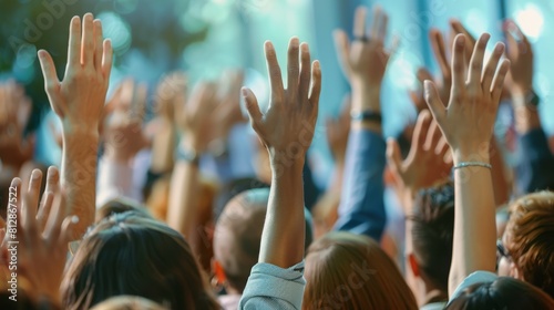 In a conference and convention at a corporate event businesspeople raise their hands to ask questions and vote. The meeting training seminar and discussions emphasize teamwork and collaboration.