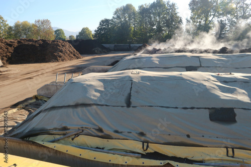Composting windrows covered with semipermeable membrane to protect them from weather conditions.