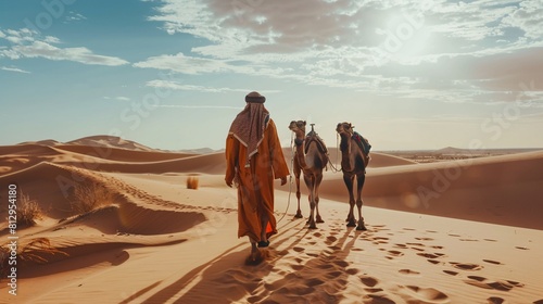 Arabic man with camels in the desert of Dubai, United Arab Emirates.
