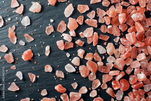 pink himalayan salt crystals scattered on black background contrasting texture closeup photography