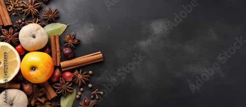 Autumn inspired ingredients like fresh apples hazelnuts and aromatic spices such as anise stars and cinnamon are arranged on a spacious gray kitchen table The composition offers a top view with ample