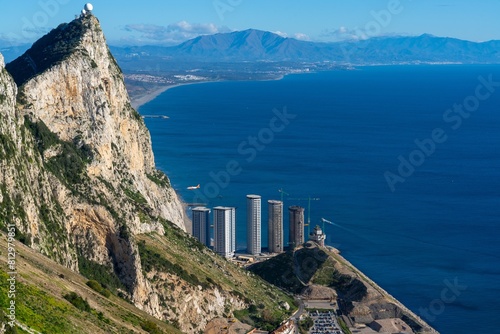 airplane lands at Gibraltar airport with a view of the Rock and new skyscrapers being built