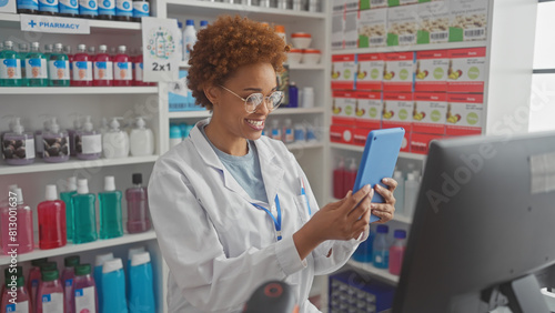 Smiling woman pharmacist using tablet in drugstore shelves stocked with products