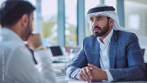 Middle Eastern businessmen in traditional attire having interview for company important position at a modern office. Modern business world and big money concept image.