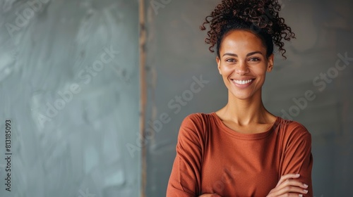 A Vertical Image Captures An Adult Woman Smiling With Her Arms Crossed, Projecting Confidence And Positivity