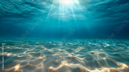 "Sandy ocean floor with blue tropical water above, clear underwater scene with the summer sun shining, making ripples in the calm sea"
