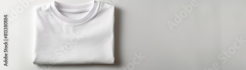 A folded white tshirt on a seamless white background, emphasizing simplicity and clean design
