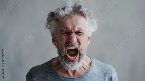 Close-up of an elderly man with a beard, yelling intensely with a furious expression. Perfect for themes related to anger, emotion, and intensity.