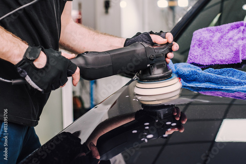 Man using a sander to polish a car's surface