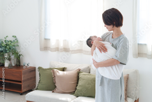 0歳の赤ちゃんを抱っこするママ