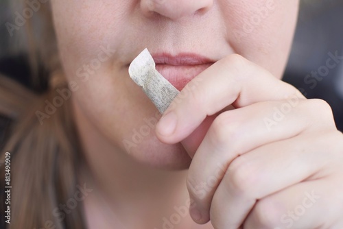 A box of snus pads replaces smokeless cigarettes. Swedish nicotine pouch. A woman holds one bag of snus in her hand. 