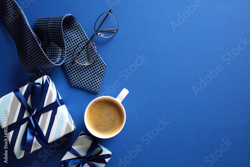 Stylish men’s gift set with coffee, glasses, and tie on blue background - perfect for Happy Fathers Day theme.