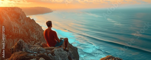 Man on cliff looks out towards the ocean