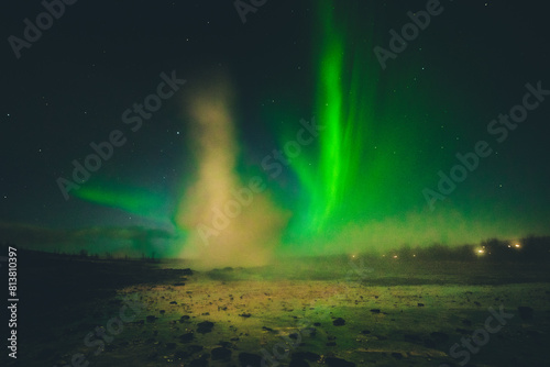 Strokkur geysir eruption at night with northern lights background. Golden Circle, Iceland