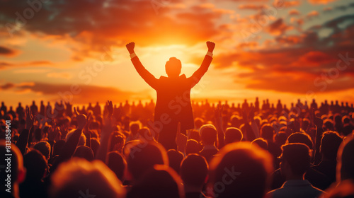 Crowd of people at a concert or festival with raised hands in front of bright stage lights