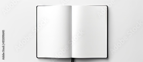 A top down view of a blank spiral bound sketchbook with an open page photographed against a white background The black and white minimalist design allows for ample copy space