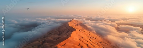 Aerial view of a drone flying over massive sand dunes covered by thick fog clouds at sunrise, Liwa desert, Abu Dhabi, United Arab Emirates realistic nature and landscape
