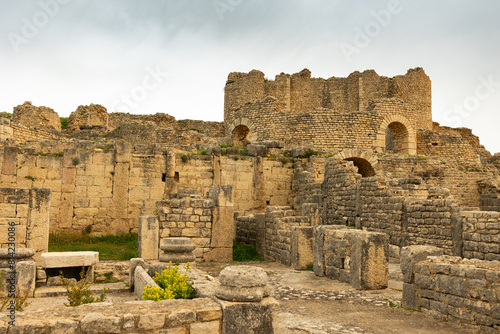 Ruins of ancient Roman Thermes de Liciniens bathing-place on area of antic city Dougga in territory of modern Tunisia. Half-destroyed buildings from time of Roman Empire.