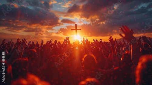 Festive crowd with raised hands praying to the cross at sunset, celebrating Christmas and Easter or worshiping in church concept .