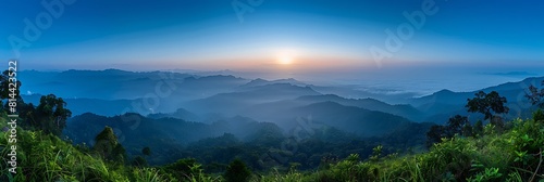 Mountain view morning panorama 180 degree of many hills and green forest cover with soft mist with blue sky background, sunrise at Solder Camp View Point, Doi Ang Khang, Chiang Mai, northern Thailand