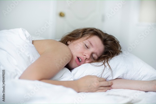 young girl sleeps in the morning in bed and snores loudly with her mouth open, the concept of person have problem with sleep and breathing