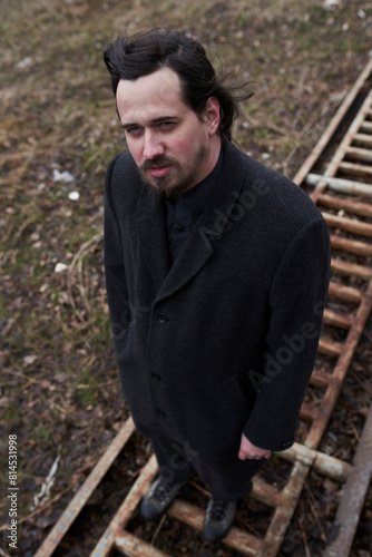 a serious man in a black coat on the street in Krasnoyarsk