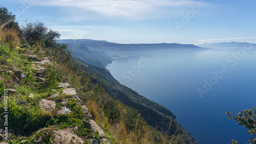 Tyrrhenian Sea bay seen from Monte Sant'Elia viewpoint during daytime with smoke rising up from active Etna volcano at Sicily, Palmi, Calabria, Italy