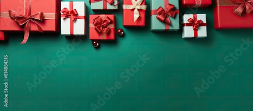 A festive greeting card showcasing gift boxes arranged on a vibrant green and red background The top down perspective provides copy space making it perfect for expressing Merry Christmas and Happy Ne