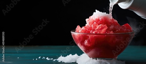 A copy space image of red syrup being poured over a Hawaiian style shave ice or snow cone