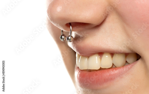 Closeup of a young smiling woman's visage with piercing septum hanging from her nose