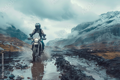 A man, a professional motorcyclist, participates in motocross racing. Driving off-road in cloudy weather, where mud and puddles make it even more difficult. Motorsport concept, extreme, speed.