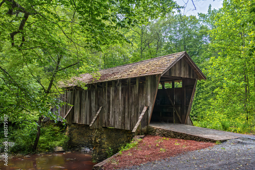 Horizontal, Pisgah covered bridge, A historic wooden bridge with a shake shingle roof, built 1911 spans the West Fork of Little River. Asheboro, Randolph County, NC. late spring, greenery everywhere. 