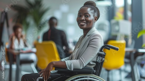 Disabled person in the wheelchair works in the office. African american woman and Her colleagues work nearby.