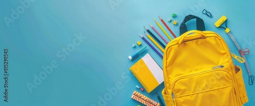 Photo of A yellow backpack with school supplies on blue background, flat lay banner for back toschool concept., Isolated color solid background