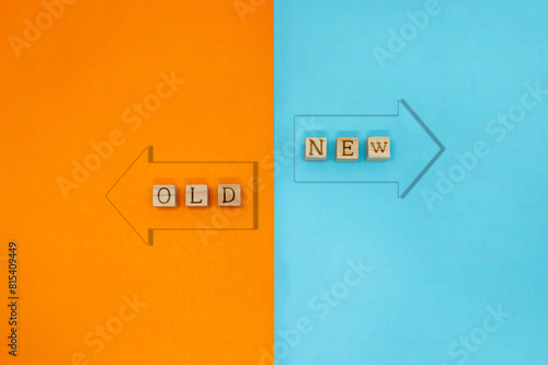オレンジと青色に分かれた背景にNEWとOLDの英語ブロックが並び浮き出た矢印