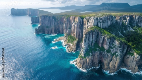 Aerial view of the Tasman Peninsula in Tasmania, Australia, showcasing the dramatic sea cliffs, clear blue waters, and lush green forests. 