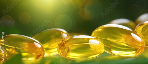 A close up image of yellow fish oil softgels is placed on a green surface serving as a background This copy space image promotes the importance of vitamins and a healthy lifestyle with a focus on ome