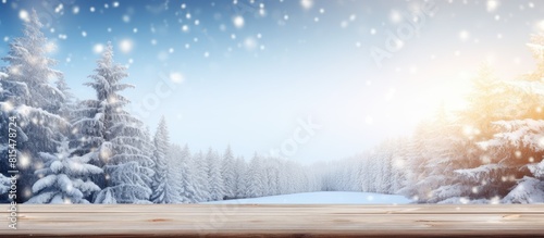 A wintry Christmas background featuring a snowy landscape with fir branches The wooden table is placed in the foreground with a blue tint and sunlight enhancing the image Plenty of copy space is avai