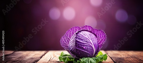 A close up image of fresh purple cabbage over a wooden background providing ample copy space