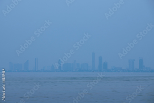 Pattaya skyline located near rippling water in a misty atmosphere, Thailand