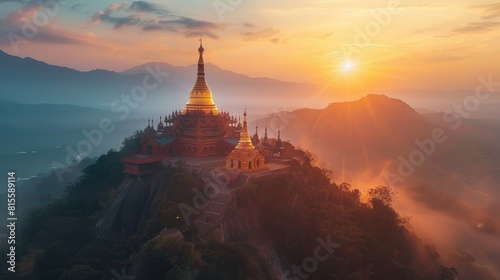A golden pagoda sits atop a hill in the middle of a lush green jungle. The sun is setting behind the pagoda, casting a warm glow over the scene.