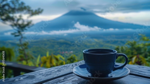 Close up a cup of black coffee and Slamet montain on the background