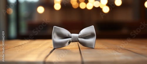 Grey bow tie on wooden table. copy space available