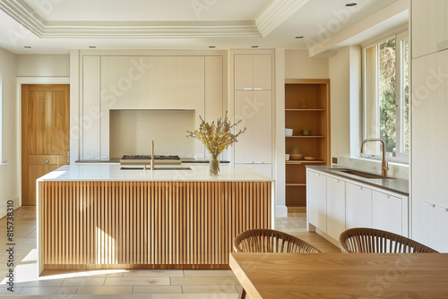 A luxury kitchen with white cabinets and an island with wood slats. A wood dining room table with chairs is in the foreground.